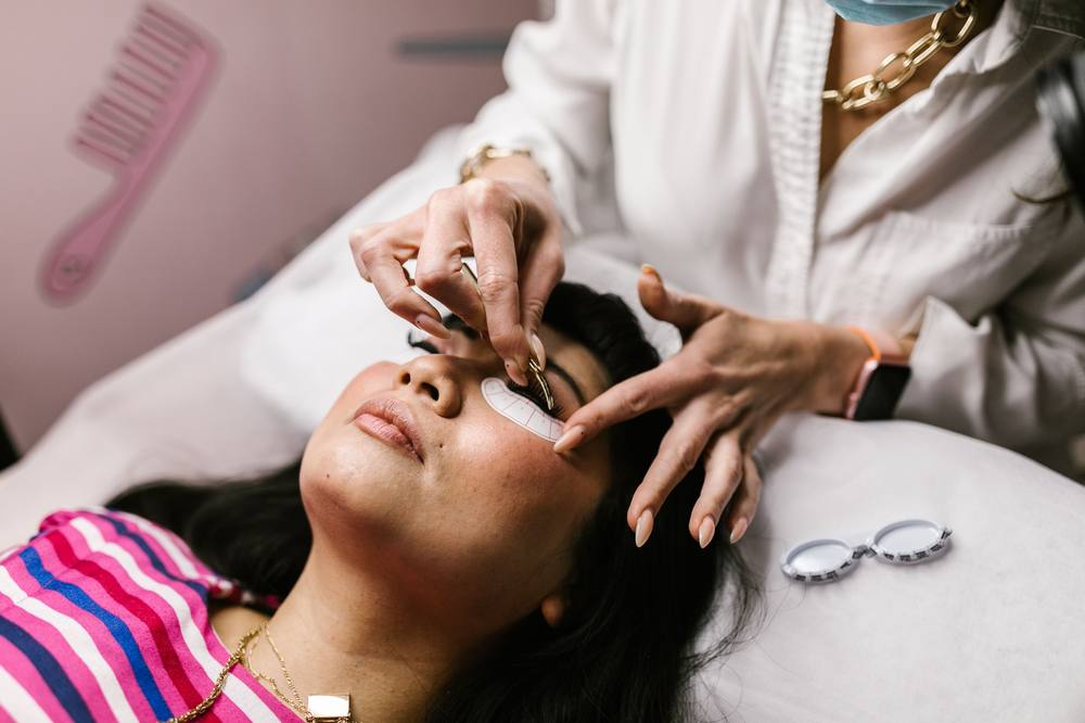 Lash designer aplicando extensão de cílios