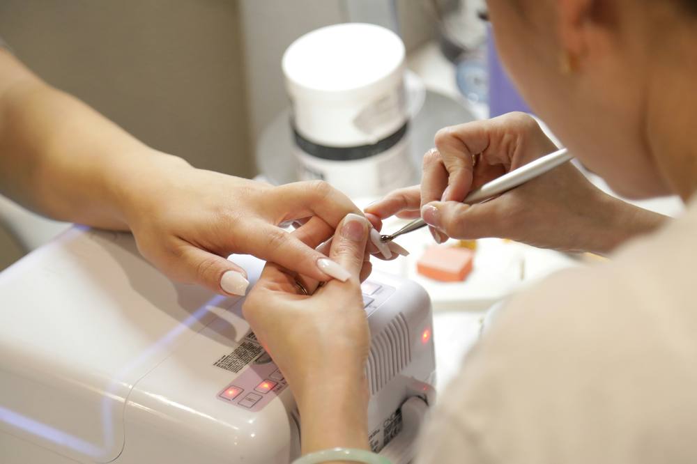 Nail designer fazendo as unhas de uma cliente